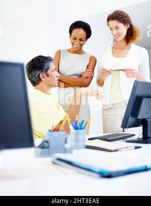 Executives discussing. Male executive sitting at table and discussing work with female colleagues. Stock Photo