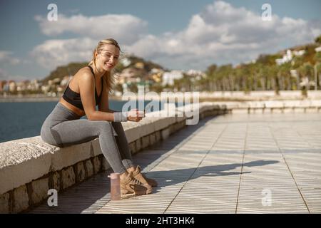 Attractive young woman posing on promenade by sea Stock Photo