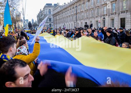 26th February 2022: Ukrainian nationals and pro-Ukraine supporters rally in Whitehall  to protest against the Russian invasion of Ukraine. London, United Kingdom. Pictured: A long banner in the colours of the Ukrainian flag is unfurled and held aloft at the demonstration in London. Stock Photo