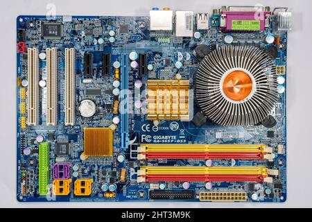 A desktop computer motherboard (Gigabyte 965P-DS3) with the CPU cooling fan removed, exposing the heat sink assembly. Stock Photo