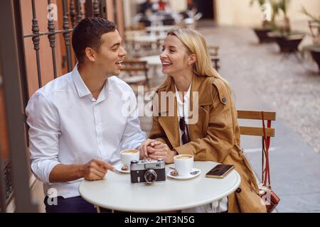 Couple laughing while sitting at cafe table during date Stock Photo