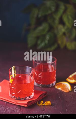 Two glasses of chocolate red orange negroni, an italian cocktail, an aperitif, first mixed in Firenze, Italy, in 1919, alcoholic bitter cocktail serve Stock Photo