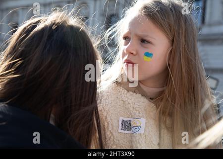 London, UK, 26th Feb 2022 A little girl and her mum join thousands who have gathered in Whitehall to protest against Russia's recent attack on the Ukraine. Stock Photo