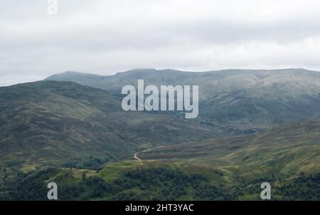 Meall Breac with cloud cover over the peak, with a winding path leading towards the peak, near Loch Rannoch, Glen Lyon, Scotland, United Kingdom Stock Photo