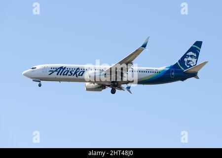 SeaTac, WA, USA - February 23, 2022; Alaska Airlines 737-900 on final approach with gear down.  Flight is from Palm Springs to Seattle Stock Photo
