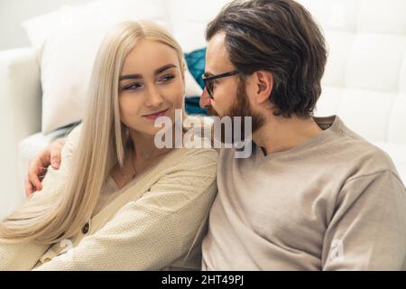 attractive caucasian long-haired blonde woman in her late 20s flirtatiously looking at her good-looking boyfriend. High quality photo Stock Photo