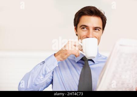 Young executive drinking coffee while looking away. Young business executive drinking coffee while looking away. Stock Photo