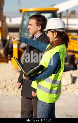 Thats where I plan to build your study. A architect talking to her contractor. Stock Photo