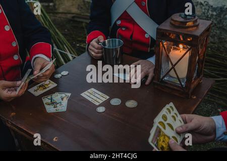 Photo of soldiers sitting around a wooden table and playing cards Stock Photo