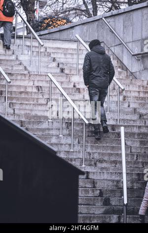 Vertical shot of a handsome man going upstairs Stock Photo