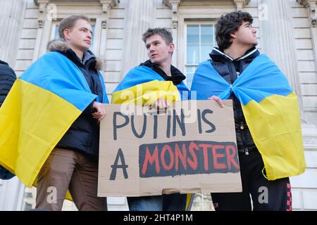 London, UK, 26th Feb, 2022, Anti-war protesters draped in Ukrainian flags were part of hundreds gathered along Whitehall in a rally and demonstration against the invasion by president Vladamir Putin's regime, calling for increased economic sanctions, such as cutting access to the Swift payment system to be imposed on Russia's banks. Credit: Eleventh Hour Photography/Alamy Live News Stock Photo