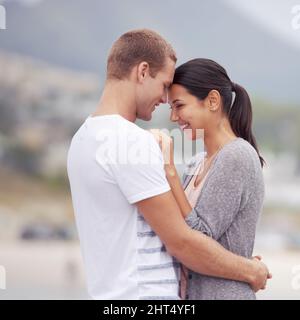 So in love. Shot of an affectionate young couple at the beach. Stock Photo