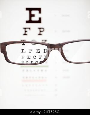 Zoom in on life. A cropped shot of eyeglasses in front of a snellen chart. Stock Photo