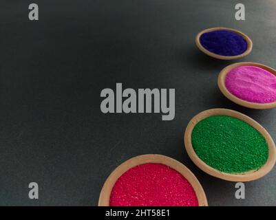 colorful powders for holi on clay pots on occasion of indian festival of colors. happy holi theme shot against black background. copy space for text. Stock Photo