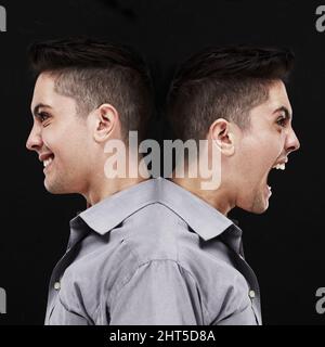 Split personality. Studio shot of a young man showing two sides of his personality. Stock Photo