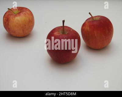 Closeup of three Indian red ripe apples placed on a white background Stock Photo