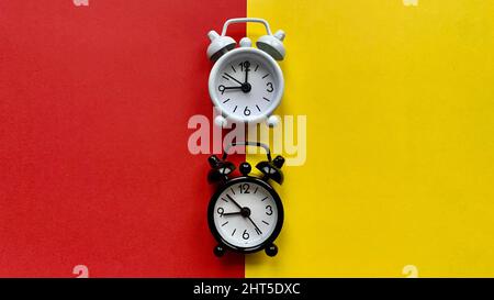 Alarm clocks on red and yellow background. Copy Space Stock Photo