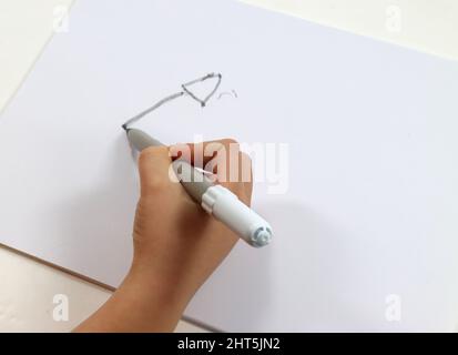 Close up of a baby toddler drawing a picture by left hand using colored  markers. Left handed child. Stock Photo by buregina