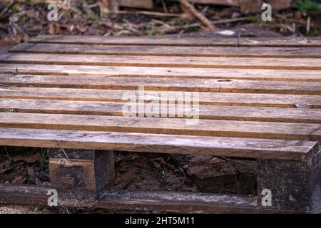 Old discarded wooden pallet on the ground Stock Photo
