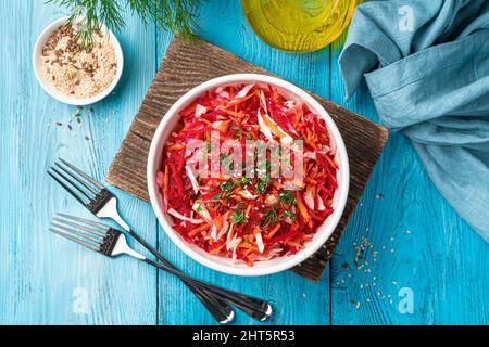 A portion of beet salad with cabbage and carrots in a white bowl. Stock Photo