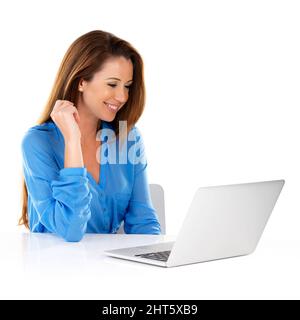 Getting some work done. Studio shot of a young woman using a laptop against a white background. Stock Photo