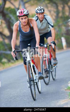 This couple enjoys competition. Shot of a couple focused on their bicycle ride together. Stock Photo