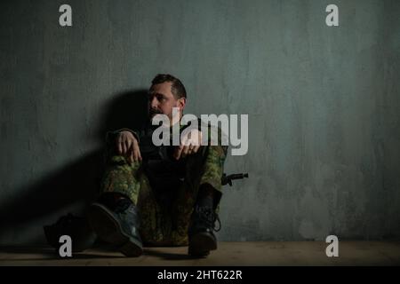 Frustrated military soldier sitting in boot camp Stock Photo