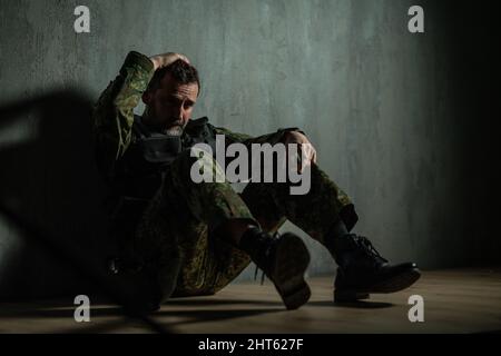 Frustrated military soldier sitting in boot camp Stock Photo
