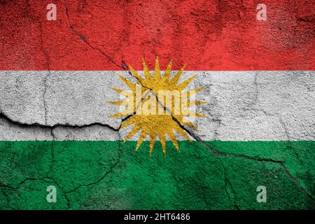 Full frame photo of a weathered flag of Kurdistan painted on a cracked wall. Stock Photo