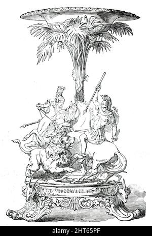 Prize Plate - Goodwood Races  - the Steward's Cup, 1850. 'A Vase of tazza form, supported by the fan-palm. The group around the base represents &quot;Alexander the Great contending with the lion.&quot; Reproving the effeminacy of his soldiers, in Persia he constantly took the exercise of war or of hunting, and exposed himself to danger and fatigue with less precaution than ever, so that a Lacedaemonian Ambassador, who attended him one day when he killed a fierce lion, said, &quot;Alexander, you have disputed the prize of Royalty gloriously with the lion.&quot;...It was designed and modelled by Stock Photo