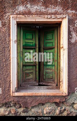 The old green window of the old stone house. Wooden wall background. Abandoned concept Stock Photo