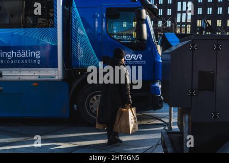 Demonstration at Freedom Square in NATO state Estonia in support of Ukraine. Woman walking on the background of a media bus Stock Photo