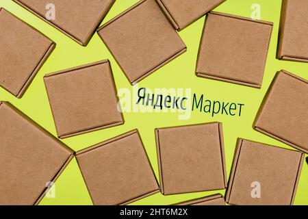Yandex.Market is russian service for choosing and buying goods. Yandex.Market logo on a white background surrounded by parcel boxes. Stock Photo