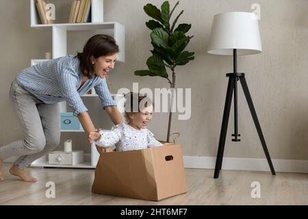Happy laughing young active mother playing with little daughter. Stock Photo