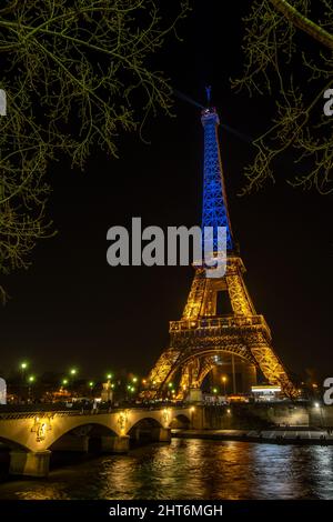 Eiffel tower dressed with the Ukrainian flag behind the bridge in Paris Stock Photo