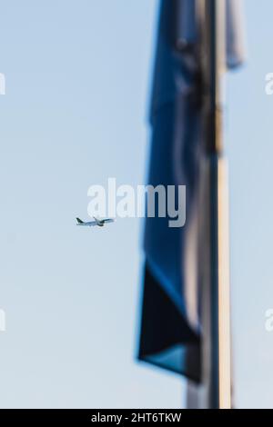 Freedom Square, Tallinn, Estonia - 02.26.2022: Air Baltic plane on the foreground of estonian flag Stock Photo