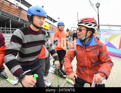 (220227) -- CHENGDU, Feb. 27, 2022 (Xinhua) -- Coach Cao Jian (R) instructs as a member of the 'Dieyun' ski team learns at a dry ski training facility in Xindu District of Chengdu, southwest China's Sichuan Province, Feb. 25, 2022. When seeing the boys and girls skiing down the slope, no one will realize they are anything different from other ski-loving youngsters until noticing their coach communicating with them mainly through writing and gesturing.   All of the 15 members of this ski team are students from the special education school in Xindu District of Chengdu, capital city of southwest Stock Photo