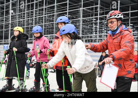 (220227) -- CHENGDU, Feb. 27, 2022 (Xinhua) -- Members of the 'Dieyun' ski team practice in a training session at a dry ski training facility in Xindu District of Chengdu, southwest China's Sichuan Province, Feb. 25, 2022. When seeing the boys and girls skiing down the slope, no one will realize they are anything different from other ski-loving youngsters until noticing their coach communicating with them mainly through writing and gesturing.   All of the 15 members of this ski team are students from the special education school in Xindu District of Chengdu, capital city of southwest China's S Stock Photo