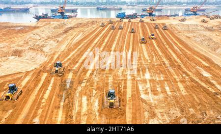 NANCHANG, CHINA - FEBRUARY 27, 2022 - Excavators and bulldozers repair exposed landmass in jiangzhou at the construction site of ecological restoratio Stock Photo