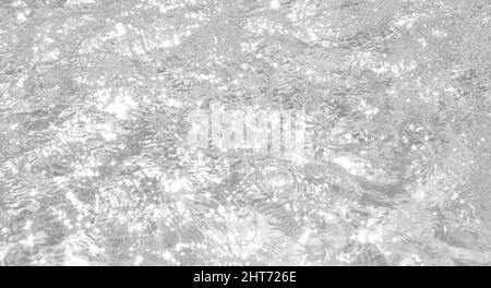 Closeup of desaturated transparent clear calm water surface texture with splashes and bubbles. Trendy abstract nature background. Stock Photo