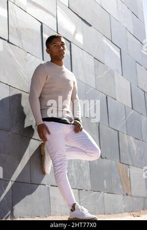 Portrait of a Hispanic male posing in trousers and a white pullover Stock Photo