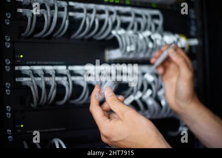 Ready to get you back online. A computer technician connecting cables. Stock Photo