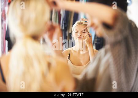Getting ready for a day on set. Pretty young woman having her makeup applied by a stylist. Stock Photo