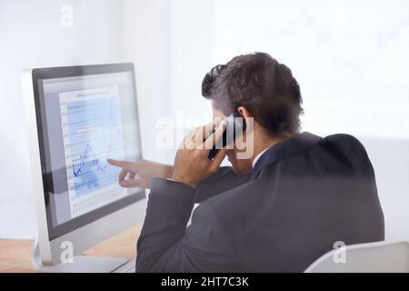 Look at those share prices. Shot of a businessman talking on the phone and pointing at a graph on his computer screen. Stock Photo