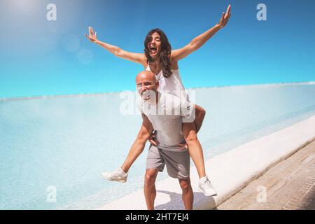 Middle-aged Hispanic couple laughing and playing lovingly on the beach Stock Photo