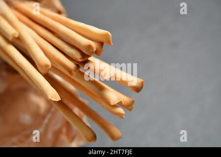 Thin breadsticks called Grissini Torinesi. Shallow depth of field. Grey neutral background for copy space. Stock Photo