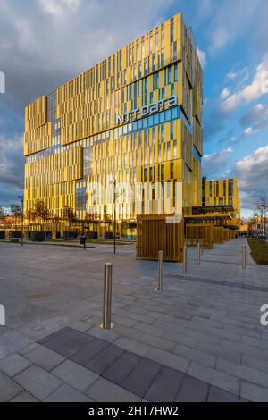 Milan, Italy - February 25, 2022: street view of sunset in Milan architecture with a brand new golden office building in Romolo area. No people are vi Stock Photo