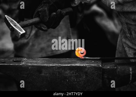 A Sword smith shaping a blade on an anvil Stock Photo