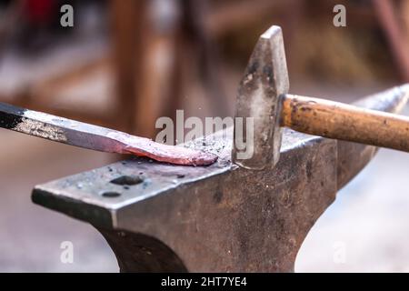 A Sword smith shaping a blade on an anvil Stock Photo