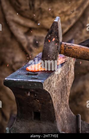 A Sword smith shaping a blade on an anvil Stock Photo